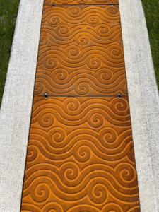 Bioswale drain channel with decorative, cast iron Argo solid covers.