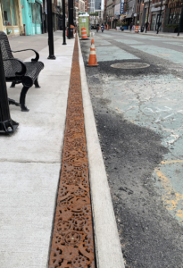 Decorative cast iron trench grates featuring interlocking gear pattern