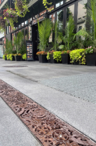 Decorative cast iron trench grates featuring interlocking gear pattern