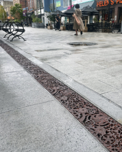 Decorative cast iron trench grates featuring interlocking gear pattern