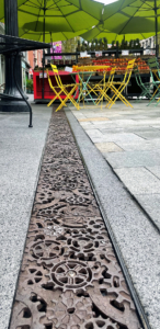 Decorative cast iron trench grates featuring interlocking gear pattern