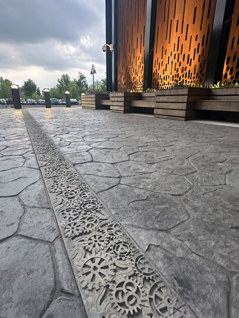 Raw Cast Aluminum solid trench grates in decorative Dynamo pattern that looks like interlocking gears from Iron Age Designs.