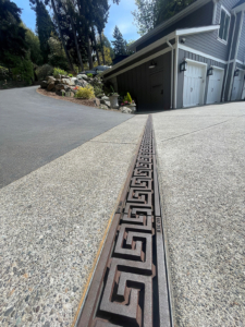 Raw cast iron trench grate in Greek Key pattern from Iron Age Designs. Installed in residential driveway.