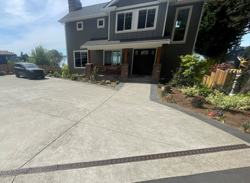 Raw cast iron trench grate in Greek Key pattern from Iron Age Designs. Installed in residential driveway.