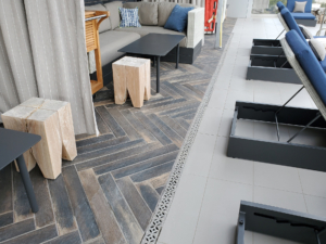 Decorative cast aluminum trench grate in classic Interlaken pattern on rooftop pool deck