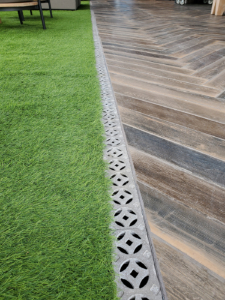 Decorative cast aluminum trench grate in classic Interlaken pattern on rooftop pool deck and restaurant