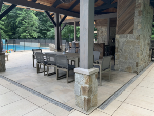 Decorative cast aluminum trench grates with Interlaken pattern installed in pool patio