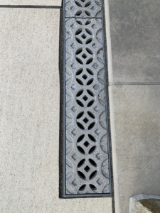 Decorative cast aluminum trench grates with Interlaken pattern installed in pool patio