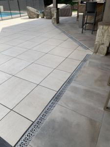 Decorative cast aluminum trench grates with Interlaken pattern installed in pool patio