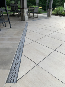 Decorative cast aluminum trench grates with Interlaken pattern installed in pool patio