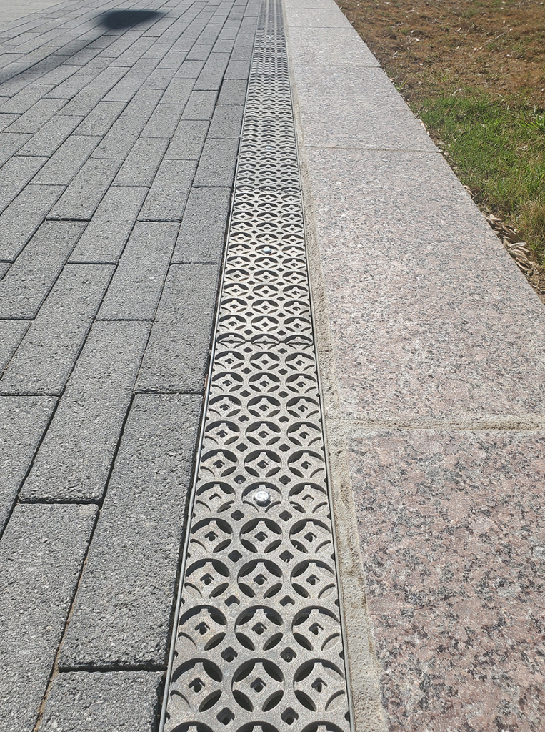 Cast aluminum trench drain grates in decorative Interlaken pattern