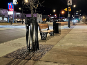 Decorative cast iron tree grate, powder coated tree guard and laser-cut steel bench ends in matching Minnione pattern