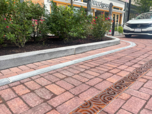 Cast iron trench grates in Oblio pattern which suggests circular ripples on water