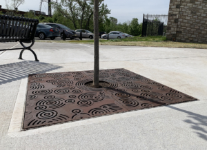 Cast iron tree grate in Oblio pattern which suggests circular ripples on water