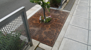 Cast iron tree grate in Oblio pattern which suggests circular ripples on water