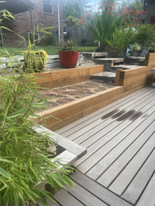 Cast iron grates used as transitional walkway on wooden deck platform