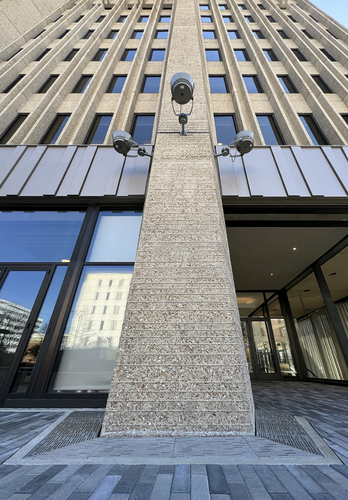Cast iron trench grate in decorative Rain pattern from Iron Age Designs. Installed in building entryway.