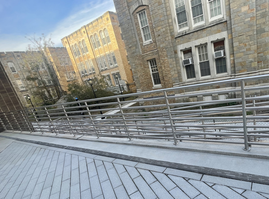 Cast aluminum decorative trench grates in Rain pattern from Iron Age Designs in college courtyard.
