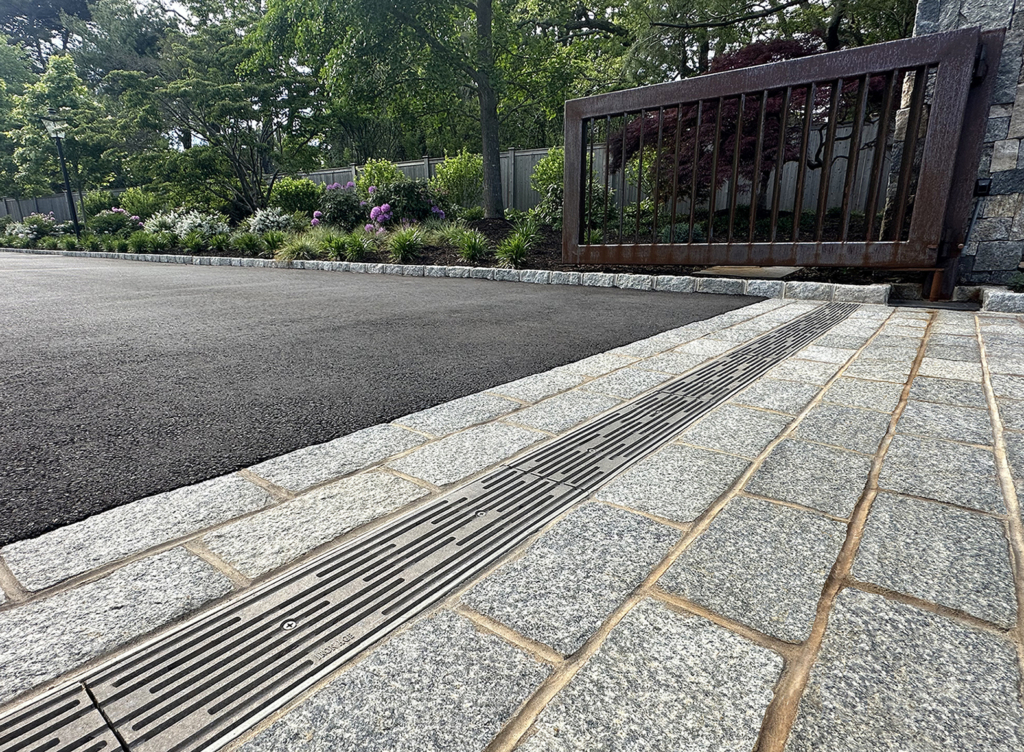 Raw cast aluminum trench grate in decorative Rain pattern from Iron Age Designs. Residential driveway installation.