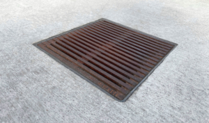 Decorative cast iron catch basin grate in Regular Joe pattern