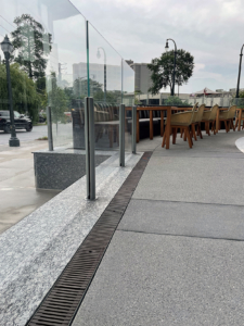 Decorative cast iron trench grates installed in outdoor hotel patio