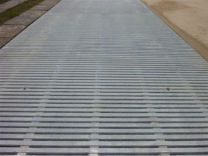 Raw cast aluminum drain grates in linear Regular Joe pattern