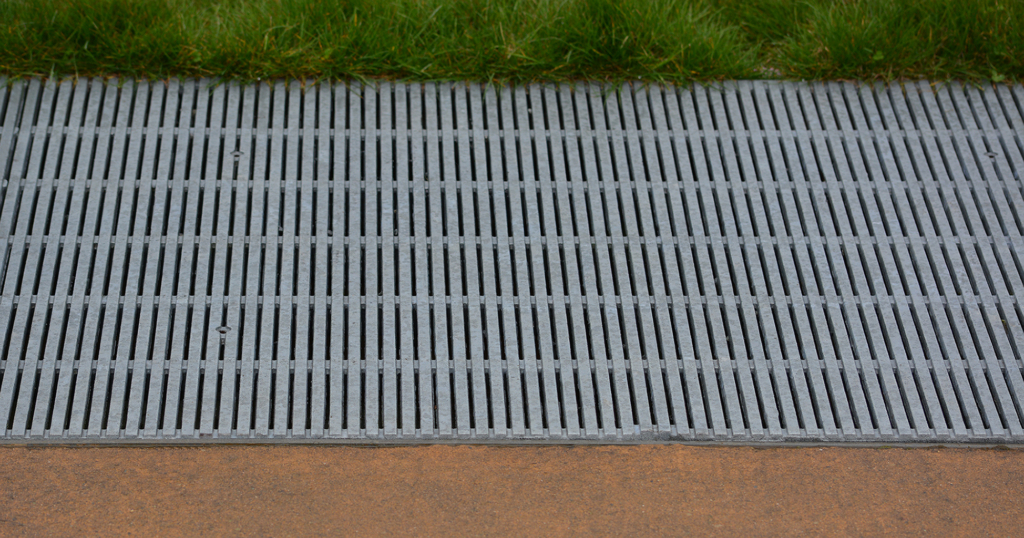 Raw cast aluminum drain grates in linear Regular Joe pattern