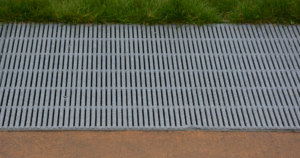 Raw cast aluminum drain grates in linear Regular Joe pattern
