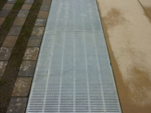 Raw cast aluminum drain grates in linear Regular Joe pattern
