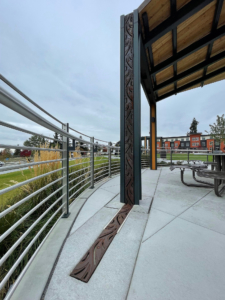 Decorative trench grates installed over pergola downspouts and in ground plane