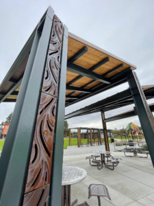 Decorative trench grates installed over pergola downspouts and in ground plane