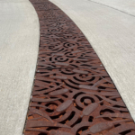 Cast iron 12" radius trench grate in decorative Tulie pattern from Iron Age Designs.