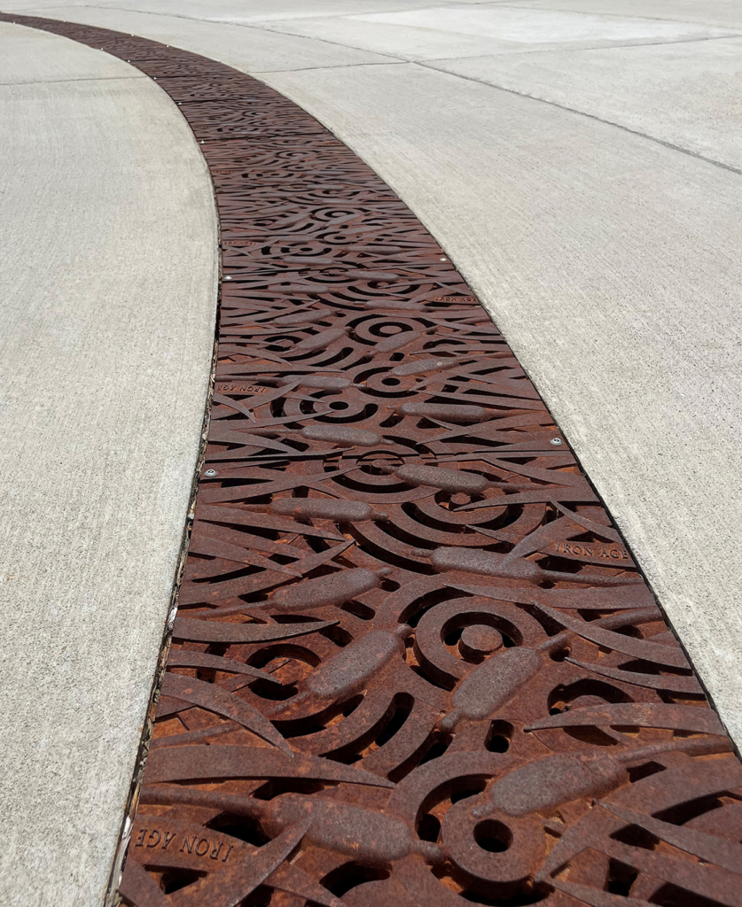 Cast iron 12" radius trench grate in decorative Tulie pattern from Iron Age Designs.
