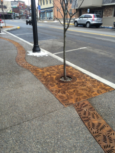 Decorative cast iron radius trench grates with Locust pattern