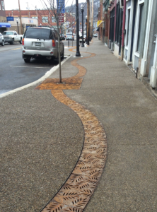 Decorative cast iron radius trench grates with Locust pattern