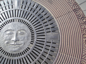 Decorative cast bronze catch basin with moon face design