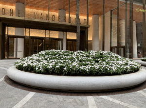 Decorative cast bronze radius trench grates in Que pattern surrounding circular planter in front of One Vanderbilt building