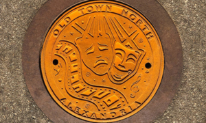 Raw cast iron plaque for Old Town North, Alexandria, VA with a film and theatre motif celebrating the city's arts and culture