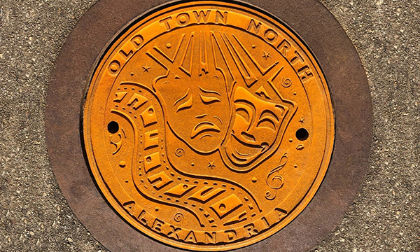 Raw cast iron plaque for Old Town North, Alexandria, VA with a film and theatre motif celebrating the city's arts and culture