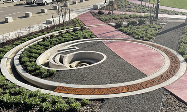 Decorative cast iron radius trench grates in a spiral drain channel