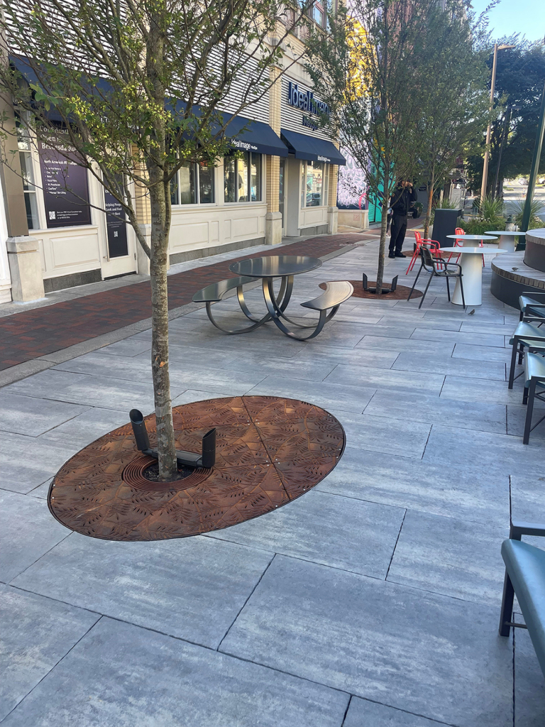 Custom cast iron elliptical tree grate in decorative Locust pattern by Iron Age Designs.