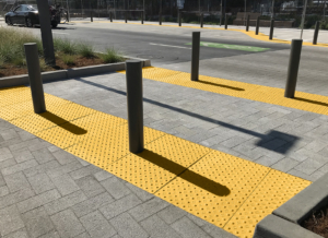 Cast iron detectable warning plate with decorative Interlaken design and yellow powder coat finish.