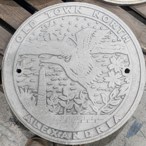 Raw cast iron plaque for Old Town North, Alexandria, VA with a nature motif featuring a heron in flight