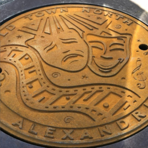 Raw cast iron plaque for Old Town North, Alexandria, VA with a film and theatre motif celebrating the city's arts and culture
