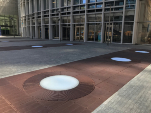 Cast iron grates surrounding LED lights, all installed in a pedestrian plaza