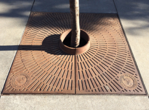 Custom cast iron tree grate with Duff Brewery logos in corners