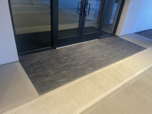 Cast aluminum decorative grates in Rain pattern arrayed as an entryway walk-off mat