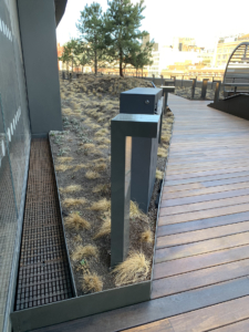 Cast iron trench drain grate in linear Plex pattern. Shown in rooftop garden.