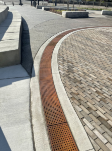 Cast iron trench grate with rounded edge holes in a grid pattern.