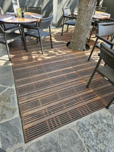 Cast iron grates with decorative Madras pattern by Iron Age Designs. Arrayed as a large tree grate.